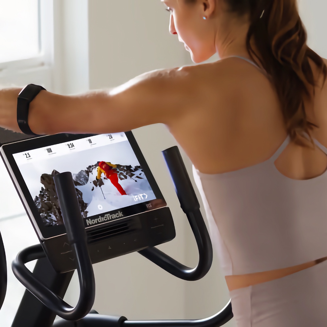 NordicTrack AirGlide 14i eliptični trenažer s 14-palčnim zaslonom in uporabnikom, ki vadi.